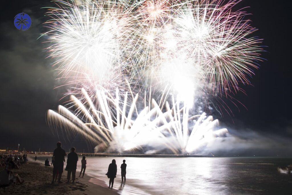Imagem mostra fogos de artifício na virada de ano na praia.